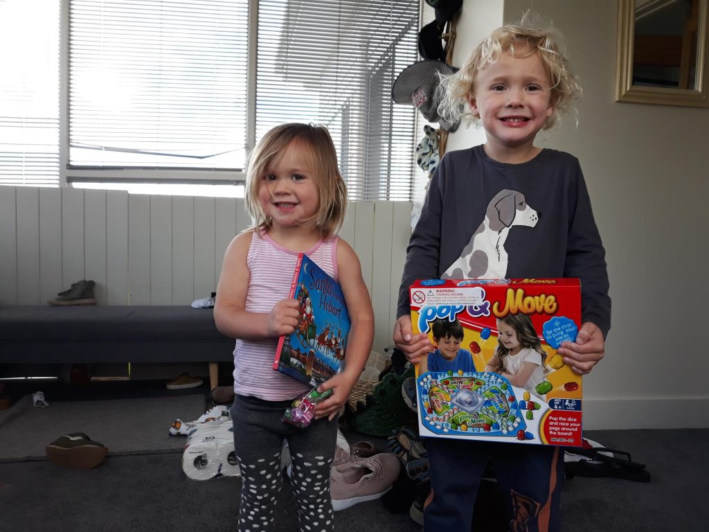 A photo of two children with their gifts.
