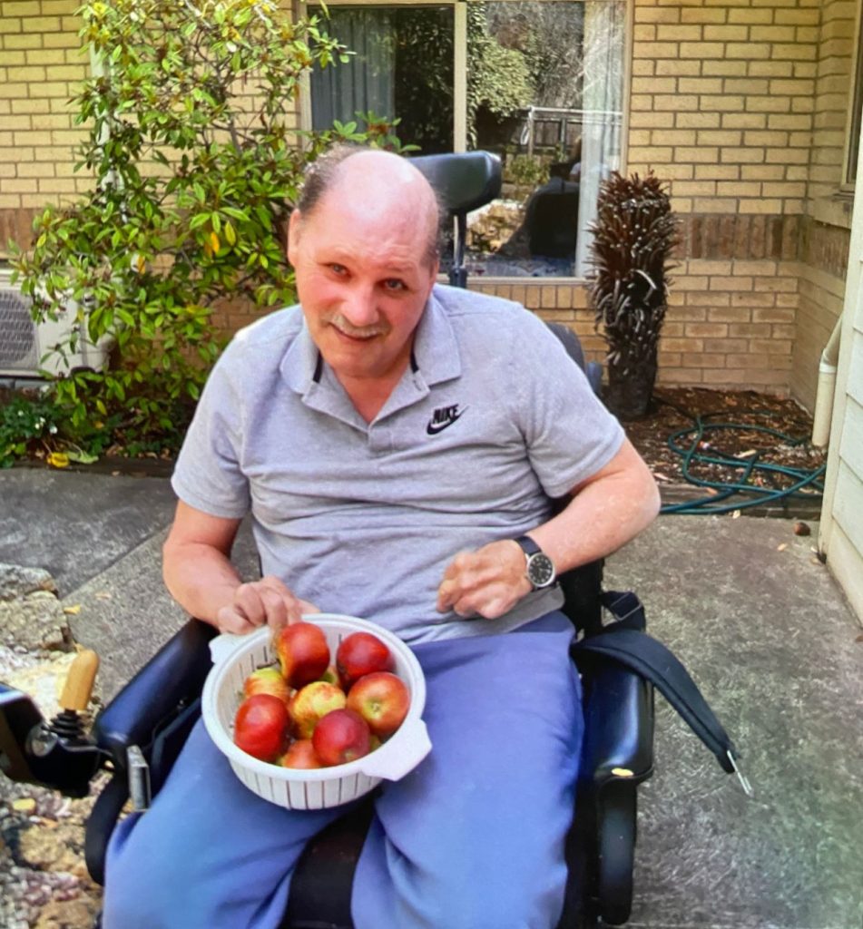Client Garry is holding a bowl of fresh apples which he has just picked from his backyard orchard.